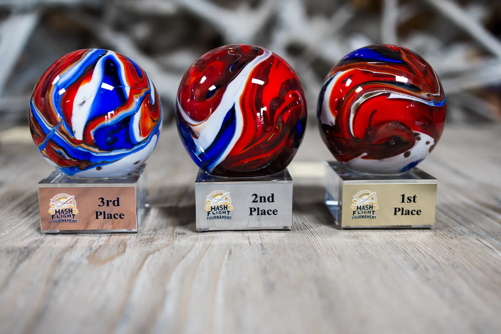 First, second and third place Hash Flight Tournament trophies with swirled red, white and blue glass orbs