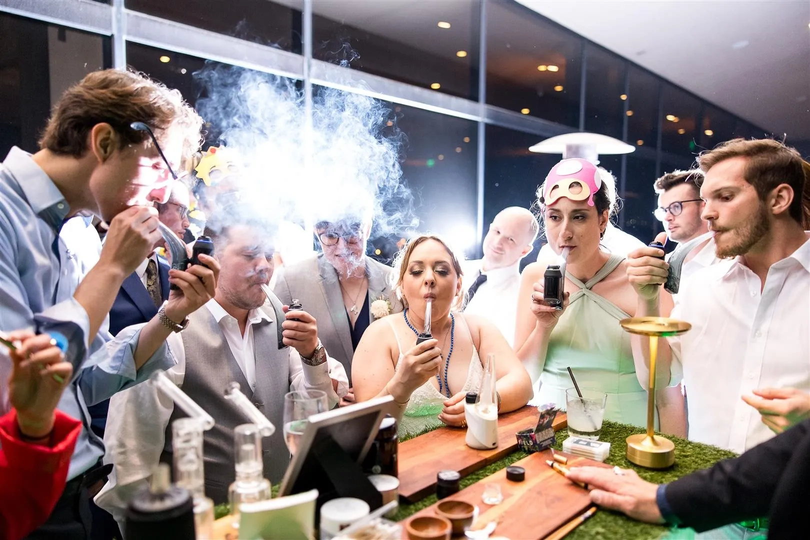 Wedding guests crowded around the cannabis bar at Carrie and Max's reception, the bride at the center