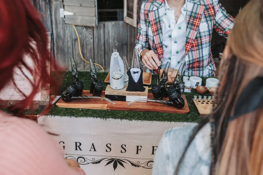 Guests lined up at the Grassfed cannabis bar while the budtender prepares their devices