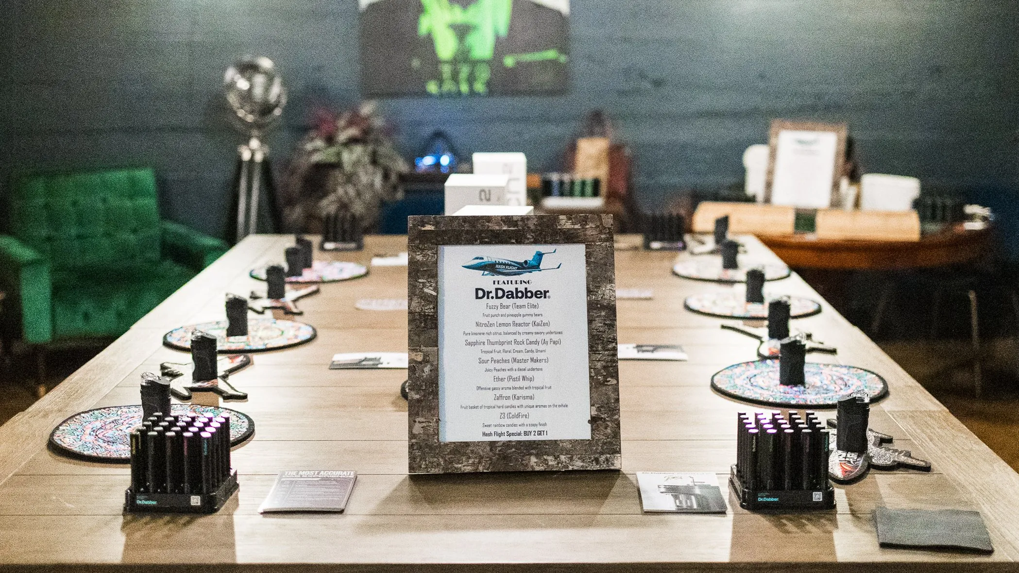 A long Hash Flight tasting table set with devices at every seat and a framed Dr. Dabber menu at the center