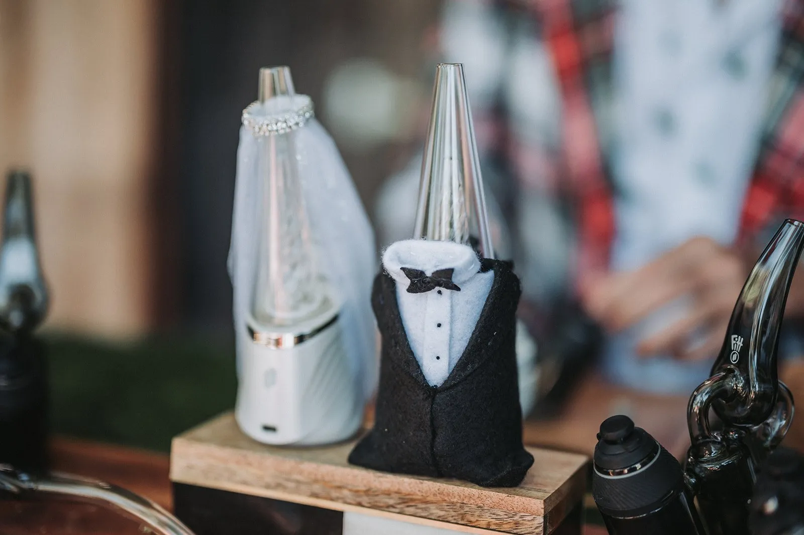 Two devices on the wedding cannabis bar dressed as a bride in a white veil and a groom in a black tuxedo