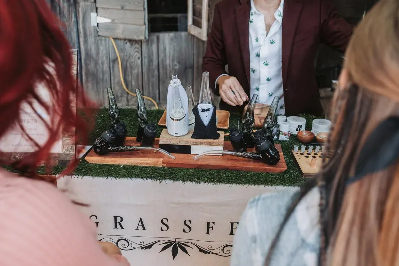 Guests lined up at the Grassfed cannabis bar while the budtender prepares their devices